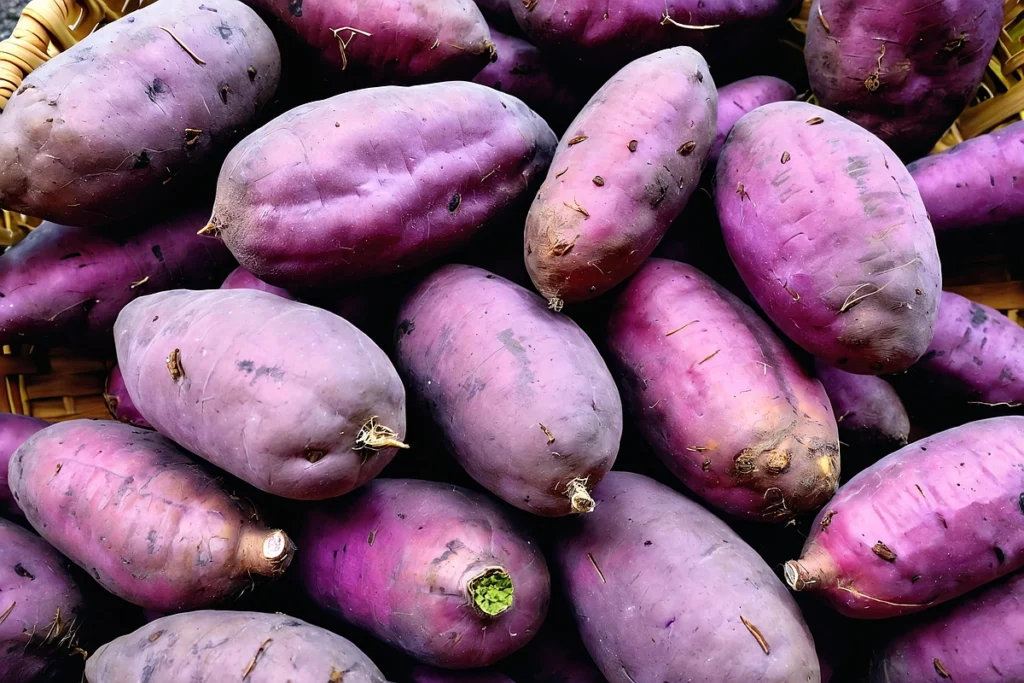 Freshly harvested purple sweet potatoes on a rustic wooden surface